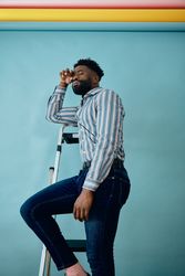 Man standing on a foldable step ladder studio portrait