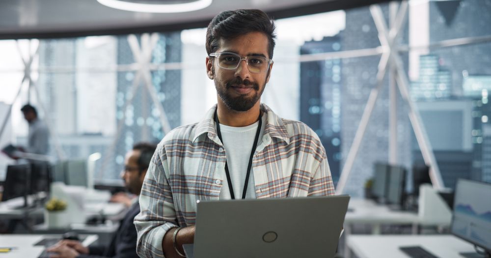 Handsome Indian Man Wearing Glasses, Charmingly Smiling and Looking at Camera.