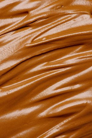 Texture of brown whipped chocolate, caramel or coffee cream, top view