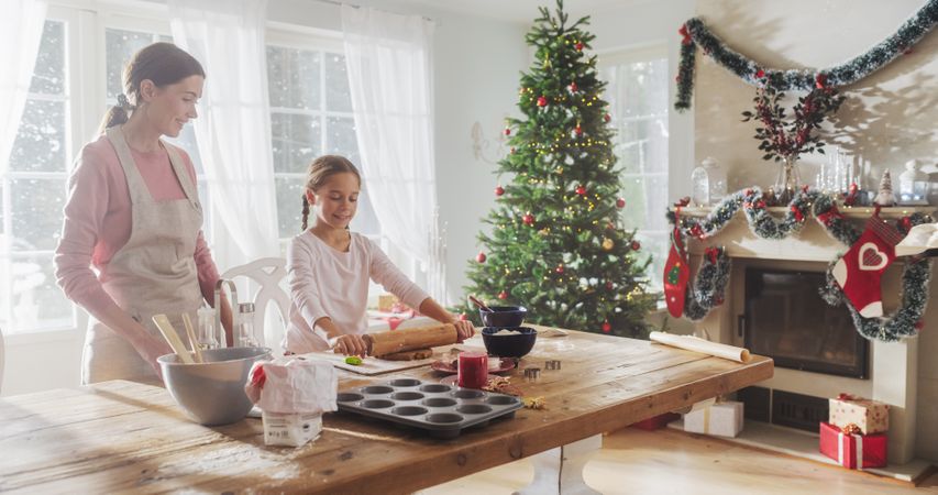 Happy Family During Christmas: Portrait of Young Mother and Her Cute Little Daughter Preparing Pastries Together at Home.