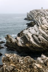 Rocky formations in the island of Baleal on the Atlantic coast in a foggy day. Peniche, Portugal