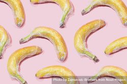 Plastic wrapped bananas on pink background bDlVAb