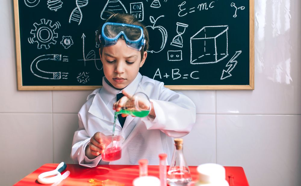 Serious kid playing with science set