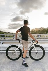 Man with bicycle standing on footbridge