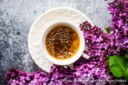 Top view of pink lilac flowers surrounding cup of espresso 4NEN8r