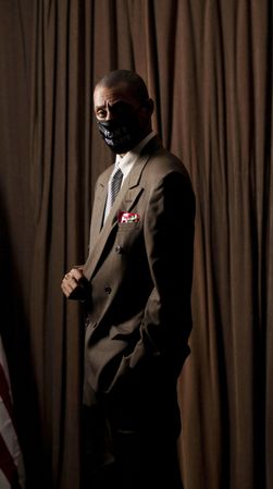 Man in brown suit with facemask standing