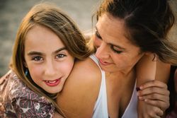 Woman with daughter on sunny beach