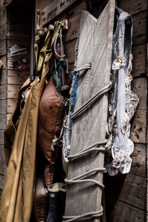 Close up of fishing clothes and board resting on wooden building