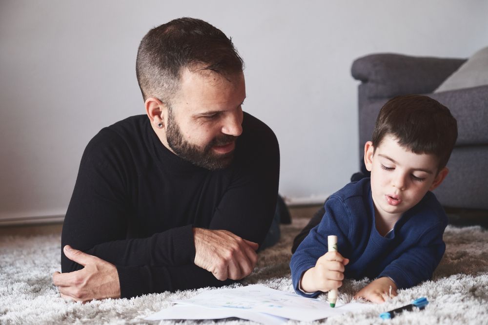 Father and son drawing on floor