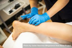 Medical professional in latex gloves doing dry needling on leg 0gxEX5