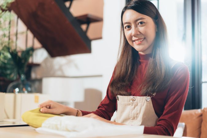 Smiling woman working with fabric at home