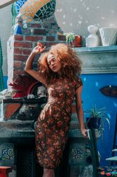 Full length fashion photo of woman holding arm up to cover face from sun