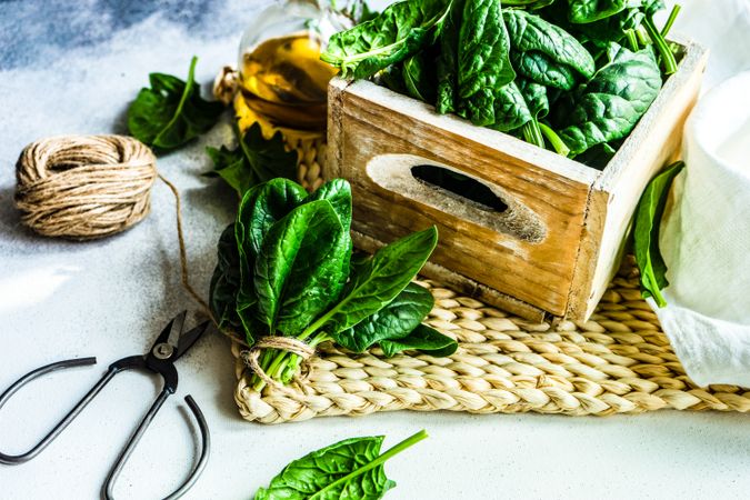 Fresh spinach salad served with oil on rattan placemat