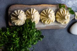 Top view of serving of Georgian khinkali dumplings with cilantro garnish and copy space