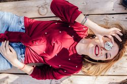 Woman looking through donuts hole on picnic