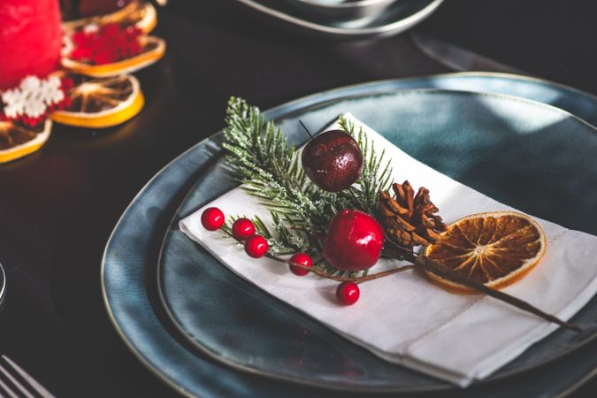 Christmas table setting with blue plate and seasonal branch