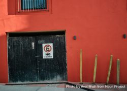 Red building and garage with no parking sign in Spanish 4BWAdb