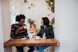 Smiling man and woman drinking coffee together at a restaurant