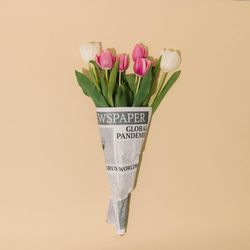 Spring tulips flowers wrapped in newspapers with Global Pandemic headline