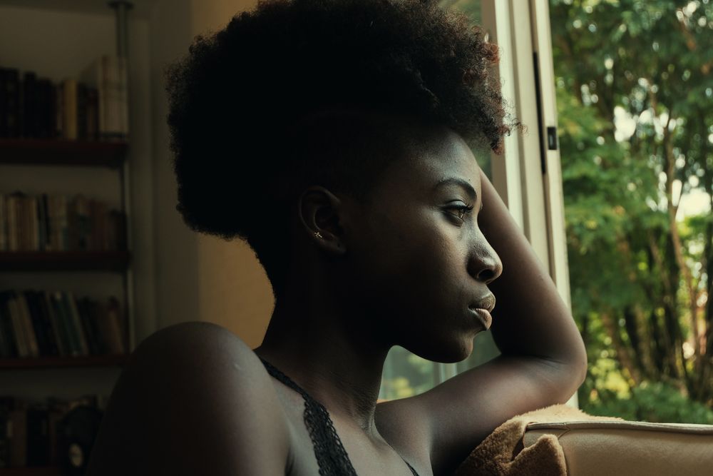 Black female leaning on a window