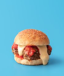 Meatballs burger with melted cheese, minimalist on a blue background