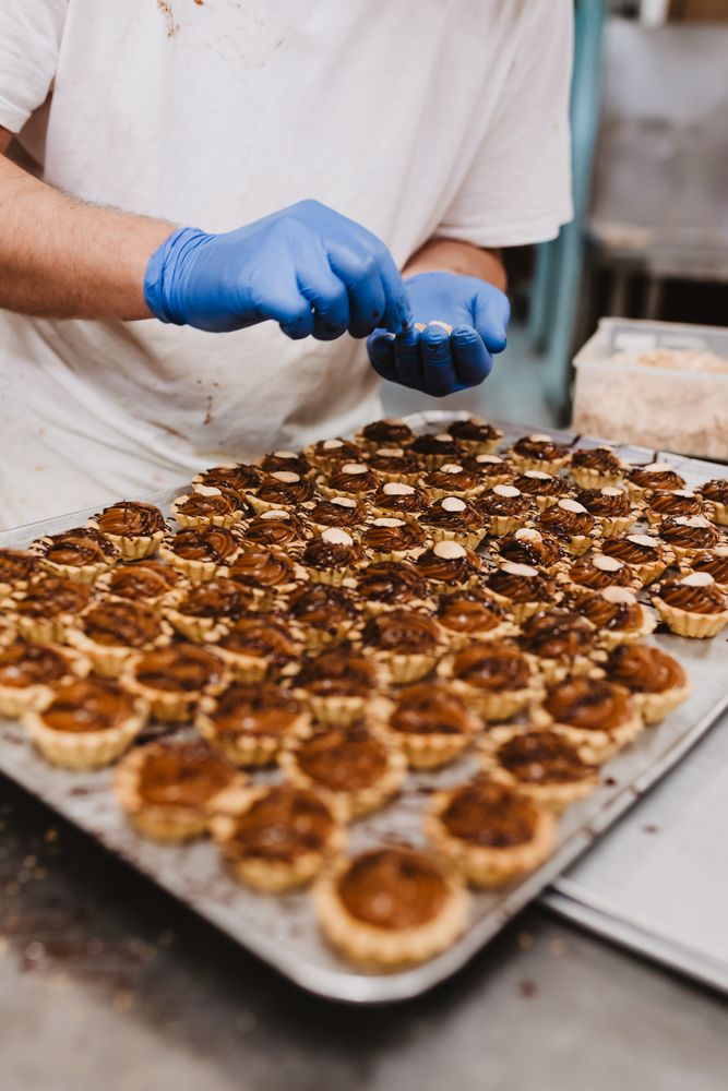 Crop cook decorating pastry with nuts