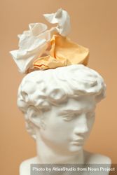 Marble bust with crumpled paper on brown background, vertical close up 479lA0