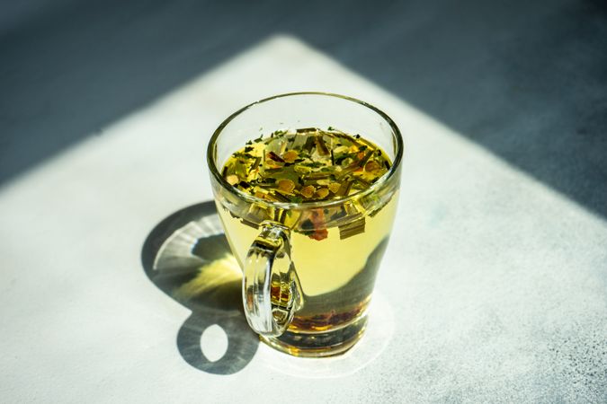 Freshly poured floral herbal tea in glass mug
