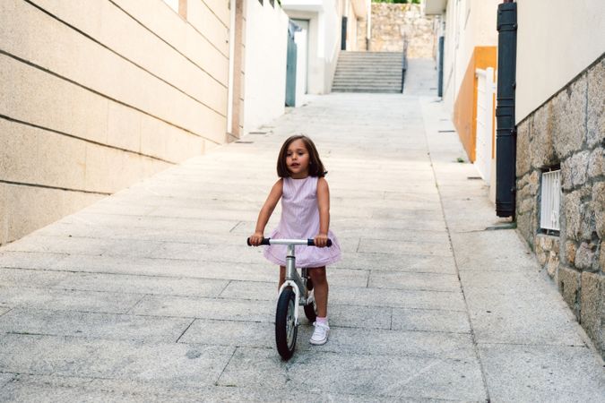 Girl riding on bicycle in narrow street