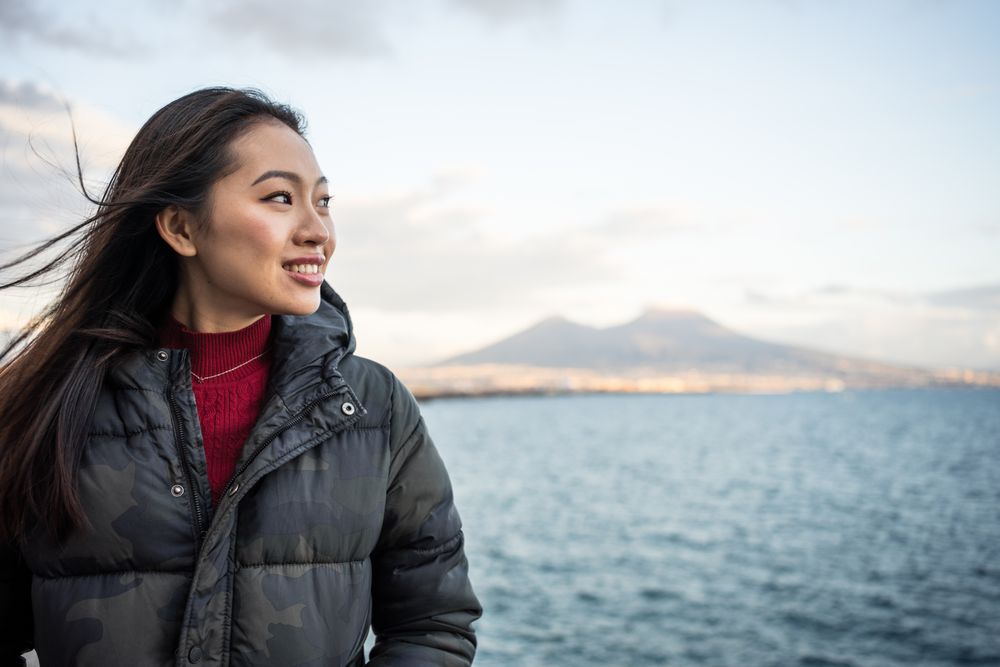 Woman on vacation in warm wear on seashore