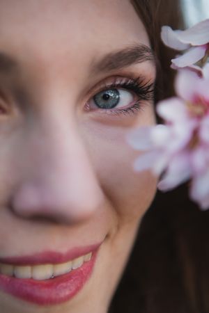 Young woman near tree twig with flowers