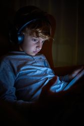 Boy playing videogame in darkness