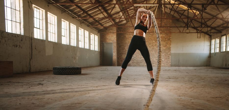 Strong woman working out inside old warehouse