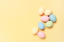Colorful eggs on yellow background with copy space