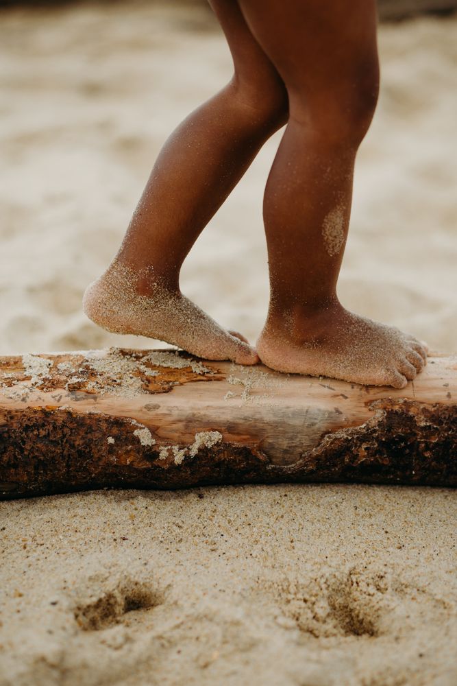 Anonymous Black kid walking on log