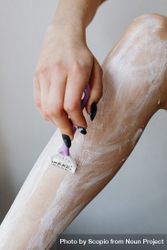 Woman shaving her leg with razor 0P92e5
