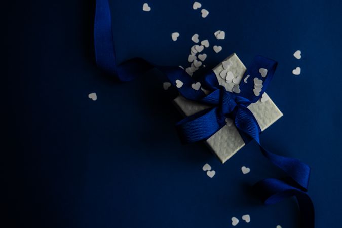 Top view of blue Valentine present with heart confetti