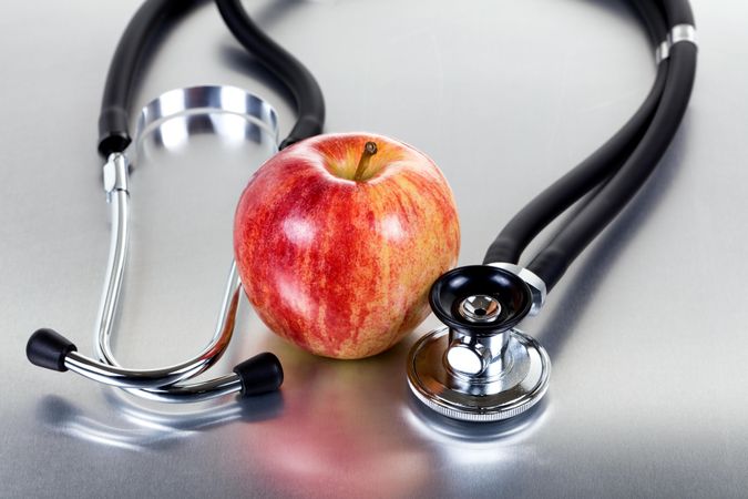 Red apple and stethoscope on stainless steel