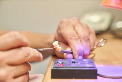 Anonymous dental specialist painting denture
