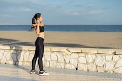 Woman stretching arm at seaside