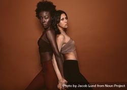Woman standing with female having vitiligo on brown background 5rODM4