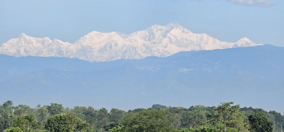 Snowy Himalayan mountains with lush green forest
