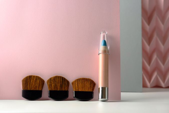 Cosmetic pencils:, make up blue eyeliner pencil, modern background with pink chevron reliefs. make up concept