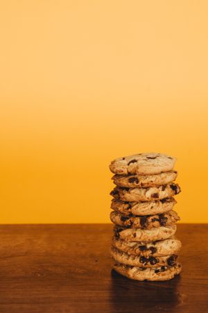 Delicious Breakfast: Cookies and Milk on a Wooden Table with an Orange Background.