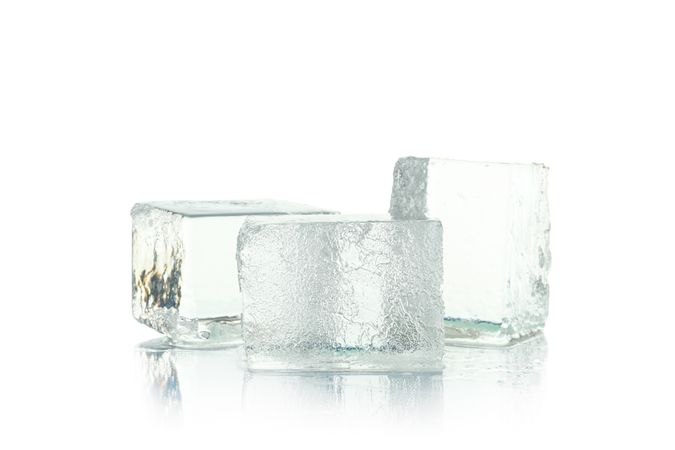 Three square ice cubes stacked in bright room