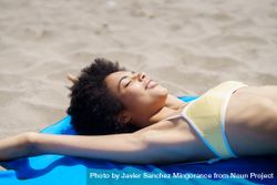 Female in yellow bikini relaxing on blue towel on the beach 5kol35