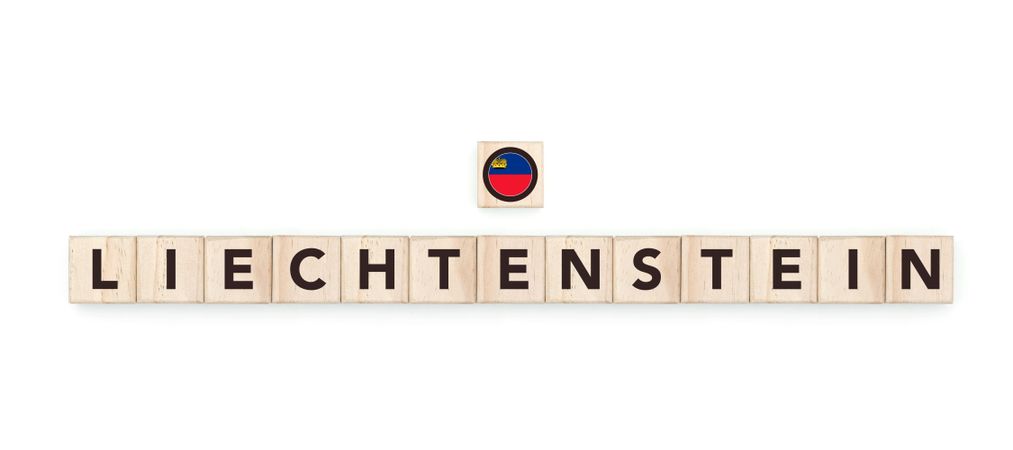 Wooden blocks bearing the name and flag of Liechtenstein. Liechtensteiner and European Culture, national identity, travel, and geography in a copy space design.
