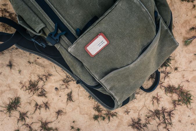 Shabby backpack on dry cracked desert area
