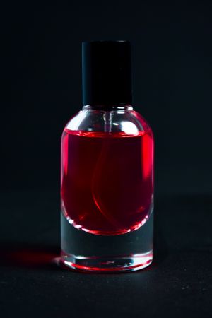 Red perfume bottle in dark studio