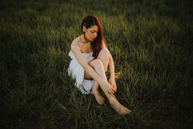 Barefoot woman with flowers in meadow